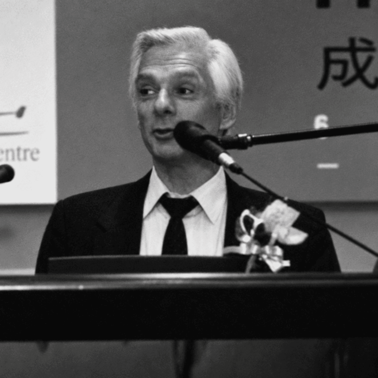 Alan P. Jeary speaking at a lectern, shown in a black-and-white archival-style photograph.